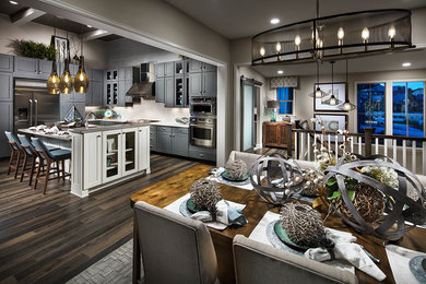 Mid-sized trendy u-shaped laminate floor open concept kitchen photo in Denver with a farmhouse sink, shaker cabinets, gray cabinets, quartzite countertops, beige backsplash, ceramic backsplash, stainless steel appliances and an island