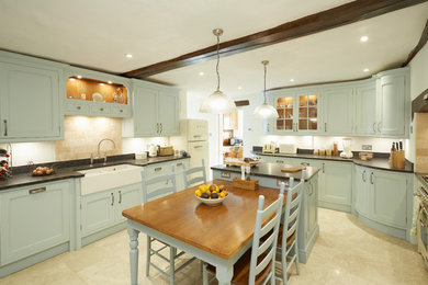 Inspiration for a medium sized farmhouse kitchen/diner in Other with a belfast sink, recessed-panel cabinets, blue cabinets, granite worktops, beige splashback, an island and beige floors.