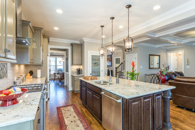 Mid-sized elegant u-shaped medium tone wood floor and brown floor eat-in kitchen photo in Raleigh with an undermount sink, raised-panel cabinets, medium tone wood cabinets, granite countertops, gray backsplash, glass tile backsplash, stainless steel appliances, an island and multicolored countertops