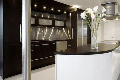 Example of a large minimalist open concept kitchen design in Miami with flat-panel cabinets, dark wood cabinets and an island