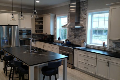 Example of a large trendy eat-in kitchen design in Orlando with a double-bowl sink, shaker cabinets, white cabinets, soapstone countertops, stone tile backsplash, stainless steel appliances and an island