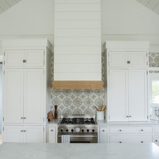 Immagine di una cucina country di medie dimensioni con lavello stile country, ante in stile shaker, ante bianche, top in marmo, paraspruzzi con piastrelle in terracotta, elettrodomestici da incasso, parquet chiaro e top bianco