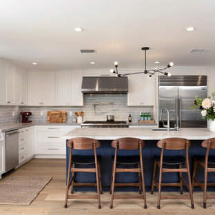 Large transitional kitchen ideas - Example of a large transitional l-shaped light wood floor kitchen design in Los Angeles with shaker cabinets, white cabinets, quartzite countertops, blue backsplash, stainless steel appliances, an island, gray countertops, an undermount sink and subway tile backsplash