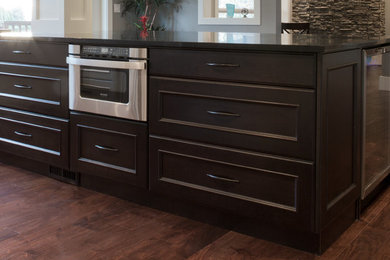 Example of a transitional u-shaped open concept kitchen design in Vancouver with louvered cabinets, dark wood cabinets, metallic backsplash and stainless steel appliances