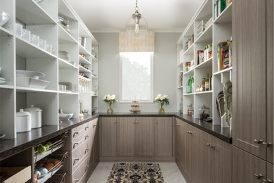 This is an example of a large u-shaped kitchen pantry in New York with recessed-panel cabinets, grey cabinets and marble flooring.