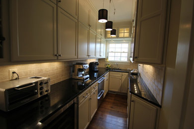 На фото: кухня в классическом стиле с паркетным полом среднего тона с