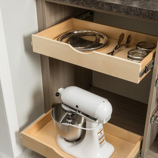 Mid-sized country u-shaped kitchen pantry in Chicago with flat-panel cabinets, medium wood cabinets, solid surface benchtops, porcelain floors, no island and grey floor.