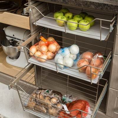 Kitchen pantry - mid-sized country porcelain tile and gray floor kitchen pantry idea in Chicago with medium tone wood cabinets, solid surface countertops and no island