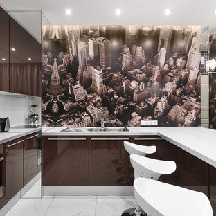 На фото: п-образная кухня-гостиная в современном стиле с двойной раковиной, плоскими фасадами, коричневыми фасадами, техникой из нержавеющей стали, полуостровом и коричневым фартуком