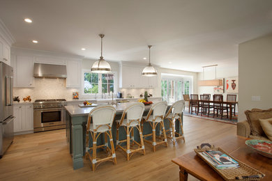 Inspiration for a mid-sized transitional medium tone wood floor eat-in kitchen remodel in Santa Barbara with a farmhouse sink, shaker cabinets, marble countertops, beige backsplash, stone slab backsplash, stainless steel appliances and an island
