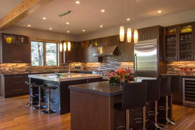 Inspiration for a large transitional l-shaped dark wood floor open concept kitchen remodel in Albuquerque with an undermount sink, flat-panel cabinets, dark wood cabinets, marble countertops, multicolored backsplash, matchstick tile backsplash, stainless steel appliances and two islands