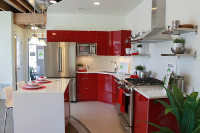 Inspiration pour une cuisine américaine minimaliste en L avec un placard à porte plane, des portes de placard rouges et îlot.