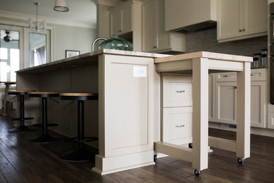 Imagen de cocina clásica renovada grande con puertas de armario blancas, electrodomésticos de acero inoxidable, una isla y armarios estilo shaker