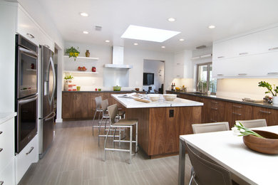 Example of a large trendy u-shaped ceramic tile eat-in kitchen design in Phoenix with an undermount sink, flat-panel cabinets, brown cabinets, marble countertops, gray backsplash, stainless steel appliances and an island