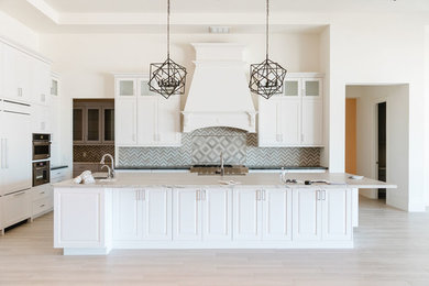Example of a transitional beige floor kitchen design in Phoenix with a farmhouse sink, shaker cabinets, white cabinets, granite countertops, white backsplash, stainless steel appliances and white countertops