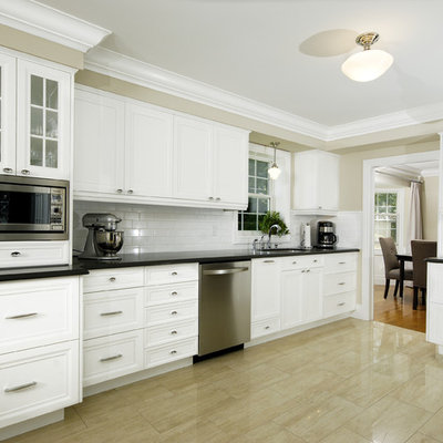 Kitchen - transitional kitchen idea in Toronto with glass-front cabinets, stainless steel appliances and subway tile backsplash