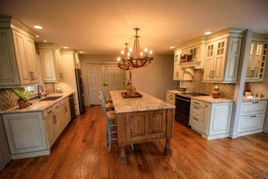 Enclosed kitchen - mid-sized farmhouse galley dark wood floor and brown floor enclosed kitchen idea in Other with an undermount sink, raised-panel cabinets, white cabinets, granite countertops, brown backsplash, porcelain backsplash, stainless steel appliances, an island and multicolored countertops