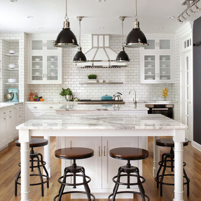 Inspiration for a large timeless l-shaped medium tone wood floor kitchen remodel in New York with marble countertops, white backsplash, subway tile backsplash, stainless steel appliances, white countertops, two islands, an undermount sink and shaker cabinets
