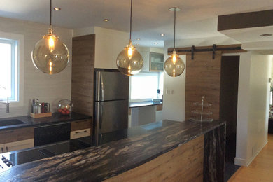Zweizeilige, Mittelgroße Rustikale Wohnküche mit Granit-Arbeitsplatte, Küchenrückwand in Weiß, Rückwand aus Keramikfliesen, Küchengeräten aus Edelstahl, hellem Holzboden und Kücheninsel in Montreal
