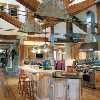 Example of a huge mountain style u-shaped medium tone wood floor open concept kitchen design in Salt Lake City with recessed-panel cabinets, blue backsplash, stainless steel appliances, granite countertops and two islands