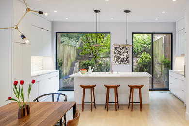 Mid-sized 1960s light wood floor and beige floor eat-in kitchen photo in DC Metro with an undermount sink, flat-panel cabinets, white cabinets, quartz countertops, an island, white backsplash and white countertops