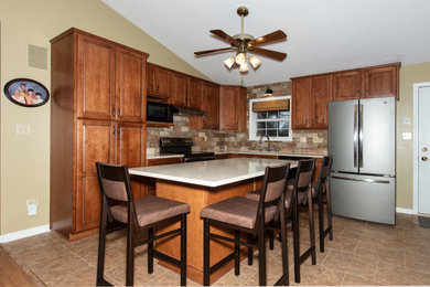 Example of a classic kitchen design in Louisville with raised-panel cabinets, quartz countertops and an island