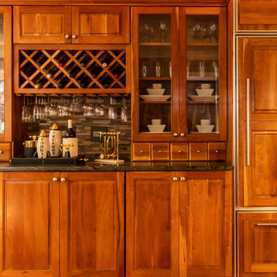 Example of a mid-sized eclectic u-shaped medium tone wood floor and brown floor open concept kitchen design in Other with a single-bowl sink, glass-front cabinets, medium tone wood cabinets, granite countertops, brown backsplash, matchstick tile backsplash, paneled appliances, a peninsula and green countertops