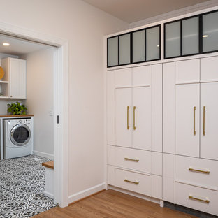 Mid-sized farmhouse open concept kitchen ideas - Mid-sized farmhouse single-wall light wood floor open concept kitchen photo in Raleigh with a farmhouse sink, flat-panel cabinets, white cabinets, quartzite countertops, white backsplash, subway tile backsplash, paneled appliances, an island and white countertops