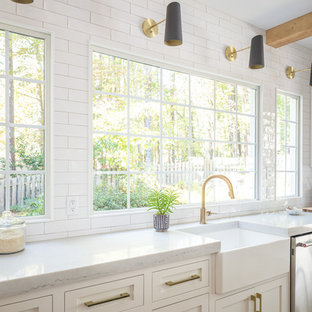 Mid-sized farmhouse open concept kitchen pictures - Example of a mid-sized cottage single-wall light wood floor open concept kitchen design in Raleigh with a farmhouse sink, white cabinets, wood countertops, white backsplash, subway tile backsplash, paneled appliances, an island, white countertops and shaker cabinets