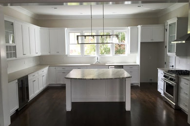 Example of a large arts and crafts u-shaped dark wood floor and brown floor eat-in kitchen design in Wilmington with an undermount sink, shaker cabinets, white cabinets, marble countertops, stainless steel appliances and an island