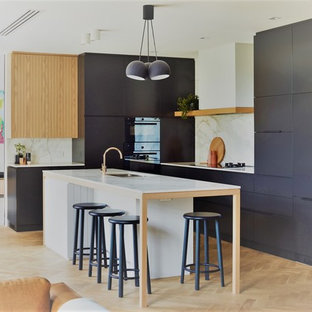 Design ideas for a contemporary l-shaped kitchen in Adelaide with an undermount sink, flat-panel cabinets, grey cabinets, white splashback, panelled appliances, light hardwood floors, with island, beige floor and white benchtop.