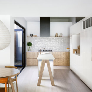 Design ideas for a contemporary l-shaped eat-in kitchen with flat-panel cabinets, white cabinets, light hardwood floors, with island and beige floor.