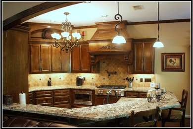 Example of a large classic u-shaped dark wood floor eat-in kitchen design in Houston with an undermount sink, recessed-panel cabinets, dark wood cabinets, granite countertops, beige backsplash, stone tile backsplash, stainless steel appliances and a peninsula