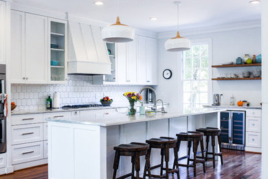 Example of a mid-sized classic galley dark wood floor and brown floor eat-in kitchen design in Richmond with a farmhouse sink, shaker cabinets, white cabinets, quartz countertops, white backsplash, ceramic backsplash, stainless steel appliances, an island and gray countertops