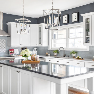 Inspiration for a huge transitional l-shaped dark wood floor and brown floor kitchen remodel in Other with a single-bowl sink, white cabinets, quartzite countertops, gray backsplash, ceramic backsplash, stainless steel appliances, an island, white countertops and shaker cabinets