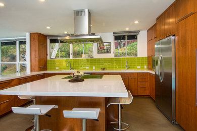 This is an example of a large contemporary u-shaped enclosed kitchen in Los Angeles with a submerged sink, flat-panel cabinets, dark wood cabinets, engineered stone countertops, green splashback, ceramic splashback, integrated appliances, concrete flooring, an island, grey floors and white worktops.