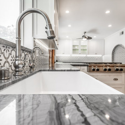 Inspiration for a mid-sized farmhouse u-shaped terra-cotta tile and red floor open concept kitchen remodel in Los Angeles with a farmhouse sink, shaker cabinets, white cabinets, quartzite countertops, gray backsplash, ceramic backsplash, stainless steel appliances, a peninsula and gray countertops