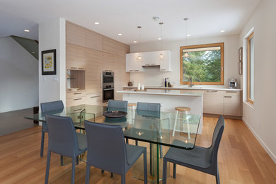 Eat-in kitchen - large contemporary single-wall light wood floor eat-in kitchen idea in Vancouver with an undermount sink, flat-panel cabinets, gray cabinets, white backsplash, stainless steel appliances and an island