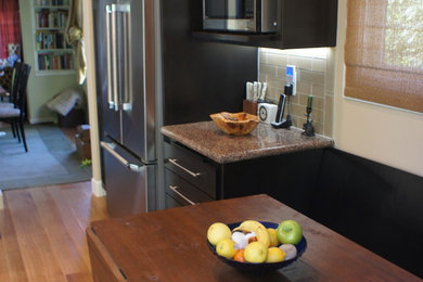 Example of a large minimalist u-shaped light wood floor open concept kitchen design in San Francisco with a double-bowl sink, shaker cabinets, dark wood cabinets, granite countertops, green backsplash, glass tile backsplash, stainless steel appliances and a peninsula