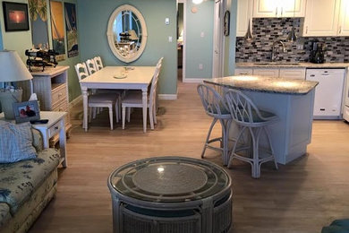 Inspiration for a mid-sized coastal l-shaped light wood floor open concept kitchen remodel in Other with an undermount sink, raised-panel cabinets, white cabinets, granite countertops, multicolored backsplash, mosaic tile backsplash, white appliances and an island