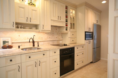 Inspiration for a mid-sized country galley ceramic tile and beige floor kitchen remodel in DC Metro with an undermount sink, raised-panel cabinets, white cabinets, beige backsplash, ceramic backsplash, stainless steel appliances, no island and gray countertops