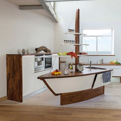 Inspiration for a coastal light wood floor kitchen remodel in Devon with an undermount sink, flat-panel cabinets, white cabinets, wood countertops, stainless steel appliances and an island