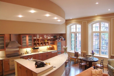 Example of a large l-shaped medium tone wood floor open concept kitchen design in Boston with a drop-in sink, medium tone wood cabinets, quartz countertops, stainless steel appliances and an island