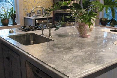 Idéer för ett modernt kök, med en undermonterad diskho, luckor med upphöjd panel, grå skåp, marmorbänkskiva, rostfria vitvaror och en köksö