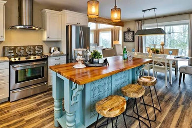Eat-in kitchen - large country l-shaped medium tone wood floor and brown floor eat-in kitchen idea in Toronto with shaker cabinets, white cabinets, granite countertops, beige backsplash, stainless steel appliances and an island