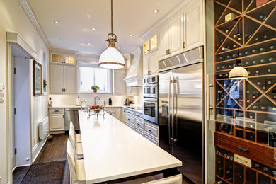 Eat-in kitchen - large traditional l-shaped ceramic tile and brown floor eat-in kitchen idea in Montreal with raised-panel cabinets, white cabinets, quartz countertops, white backsplash, subway tile backsplash, stainless steel appliances, an island and an undermount sink