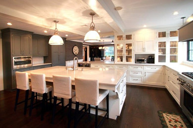 Huge transitional l-shaped dark wood floor eat-in kitchen photo in Philadelphia with an undermount sink, shaker cabinets, white cabinets, solid surface countertops, stainless steel appliances and an island