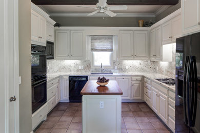 ニューオリンズにある高級なトランジショナルスタイルのおしゃれなキッチン (シングルシンク、レイズドパネル扉のキャビネット、御影石カウンター、セラミックタイルの床) の写真