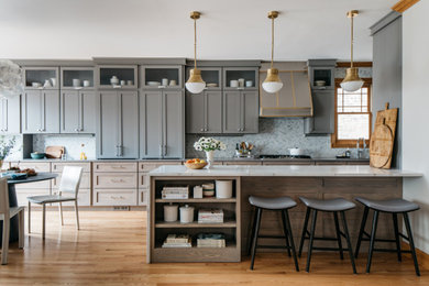 Inspiration for a transitional galley medium tone wood floor open concept kitchen remodel in Denver with an undermount sink, shaker cabinets, quartz countertops, marble backsplash, paneled appliances and a peninsula