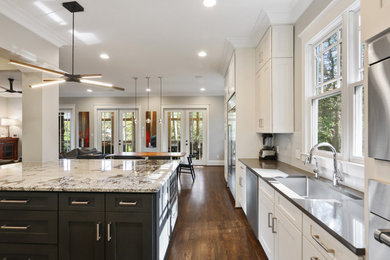 Large minimalist l-shaped dark wood floor and brown floor eat-in kitchen photo in Atlanta with a double-bowl sink, shaker cabinets, white cabinets, granite countertops, gray backsplash, glass tile backsplash, stainless steel appliances, an island and white countertops